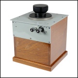 [00045] Przisions-Drehkondensator 0 - 1100 pF in massiver Ausfhrung in einem Holzgehuse; groer Drehknopf mit Skalenscheibe und Markierungen alle 10 pF; Anschluss ber verchromte, massive Schraubklemmen.